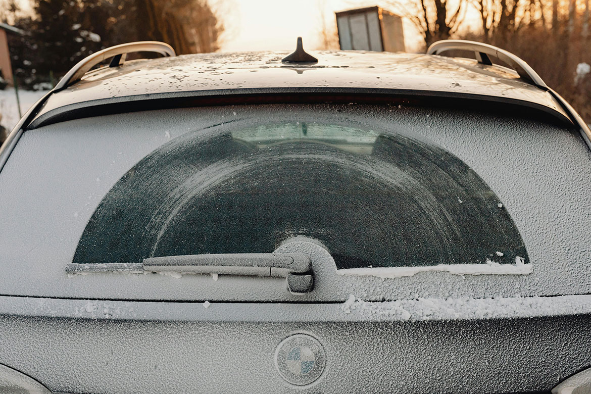 Car windscreen with wipers clearing rain or frost